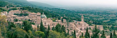 Santa Chiara Bazilikası 'nın panoramik yüksek açılı ormanlık dağları ve sisli gökyüzü arkaplanı