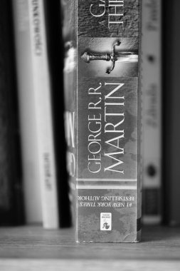 George R. R. Martin 'in A Game of Thrones romanının dikey gri tonlu yakın çekimi..