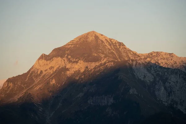 夕日の黄金の時間と丘の上の光で山の頂上の景色の美しいショット — ストック写真