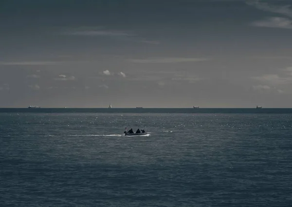 Вид Море Човном Пливе Обрії Три Людини Похмурому Тлі Неба — стокове фото