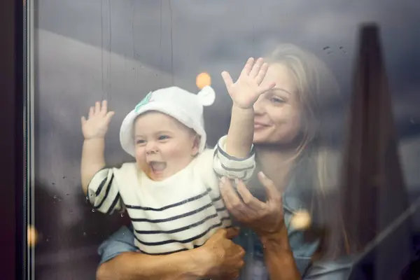 Mor Som Omfamnar Sitt Glada Barn Bakom Glasfönstret — Stockfoto