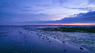 Portsmouth Limanı Pembe günbatımında Porchester Kalesi 'ne demirlemiş tekneler