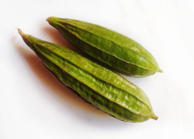 Beyaz arka planda yeşil açılı luffa sebzeleri.