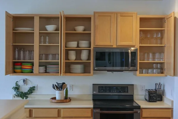 Sebuah Dapur Dengan Lemari Kayu Terbuka Dengan Peralatan Meja Yang — Stok Foto