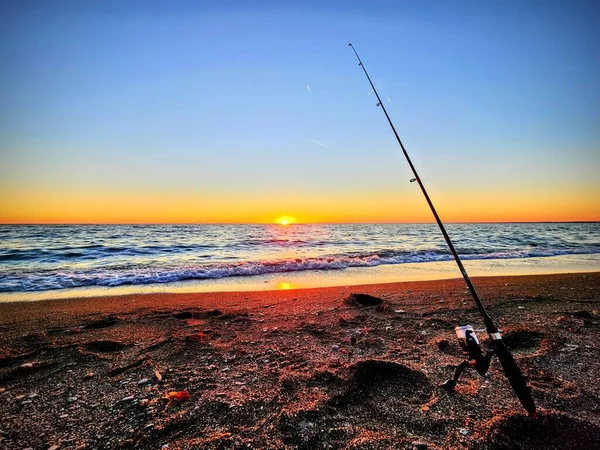 Nahaufnahme Einer Angelrute Sand Umgeben Vom Meer Während Des Sonnenaufgangs — Stockfoto