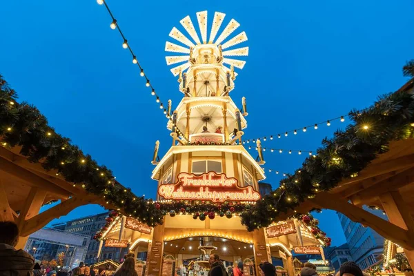 Akşam, Frankfurt, Almanya 'daki Rossmarkt Noel pazarında Noel piramidinin düşük açılı bir görüntüsü.