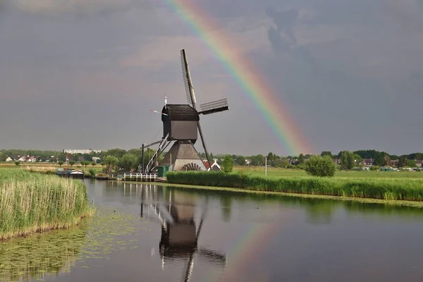 Een Windmolen Voor Een Rivier Landbouwgrond Onder Prachtige Regenboog — Stockfoto