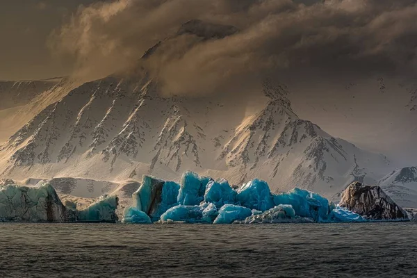 Karlı Bir Dağın Önündeki Gölde Yüzen Mavi Buzdağları — Stok fotoğraf