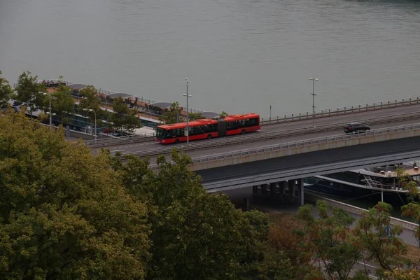 ブラチスラバ スロバキアの水の上の道路上の赤いバスと車の運転の高角度ショット — ストック写真