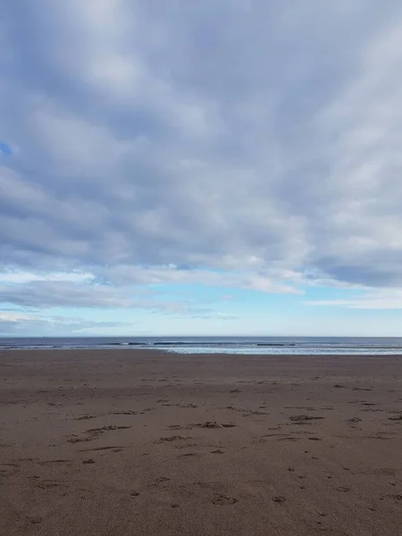 Вертикальний Знімок Яких Океанічних Хвиль Піщаному Пляжі Під Хмарним Небом — стокове фото