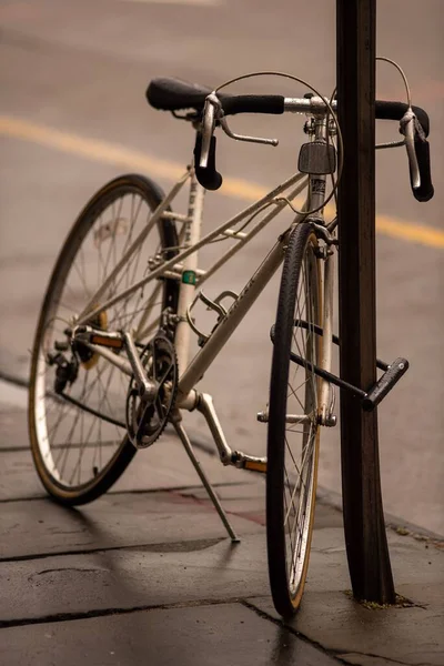 Colpo Verticale Una Bicicletta Parcheggiata Sul Lato Una Strada — Foto Stock