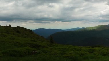Ciucas dağlarının manzarası bulutlu bir gökyüzünün altında yeşil bitki örtüsüyle sıralanır.