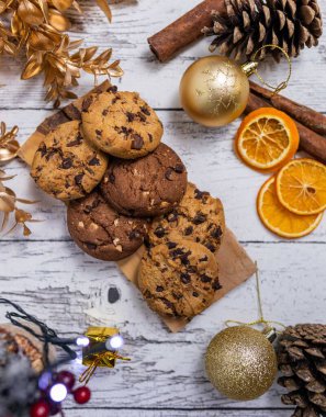 Noel süsleriyle süslenmiş masanın üzerindeki çikolatalı kurabiyelerden oluşan dikey bir üst yaşam formu.