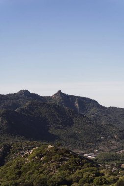 Kırsal kesimdeki mavi gökyüzünün altındaki kayalık dağların dikey görüntüsü.