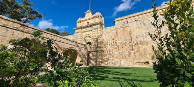 Güneşli bir günde Mdina Kapısı 'nın arka planında Mdina, Malta' da bulutlu mavi bir gökyüzü