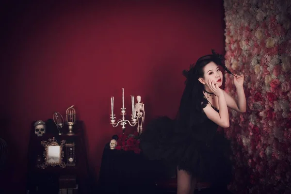 Stock image A beautiful east Asian girl wearing a black tutu dress posing in a gothic styled room