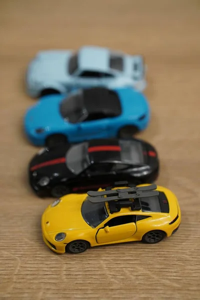 Küçük Porsche Araba Modellerinin Dikey Görüntüsü Tahta Bir Yüzey Üzerinde — Stok fotoğraf