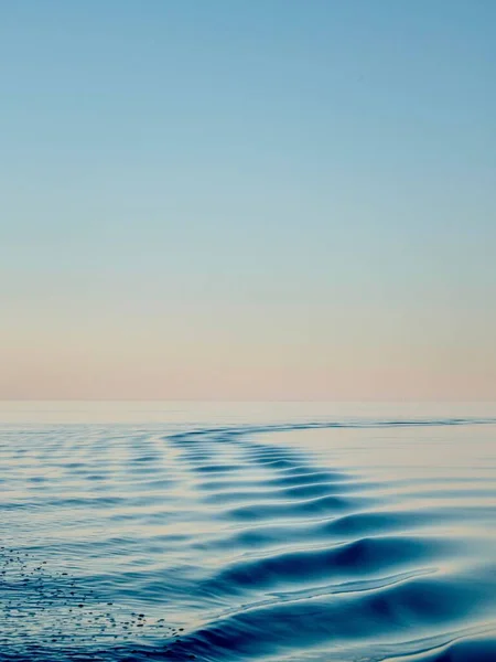 Gün Batımında Mavi Bir Suyun Yüzeyindeki Dalgaların Dikey Görüntüsü Arka — Stok fotoğraf