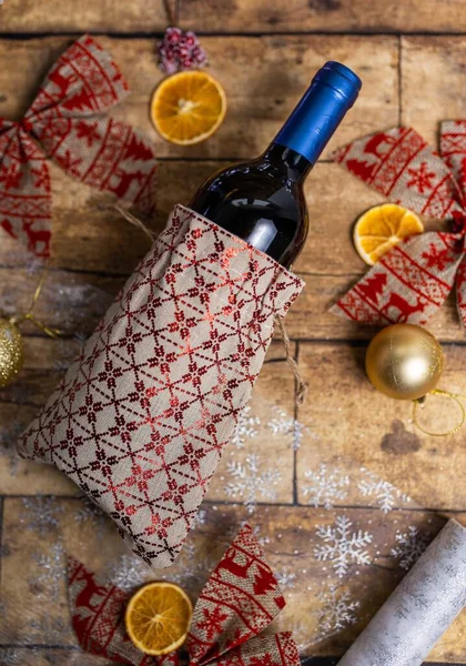 Noel Süsleriyle Süslenmiş Ahşap Masada Duran Bir Şişe Şarabın Dikey — Stok fotoğraf
