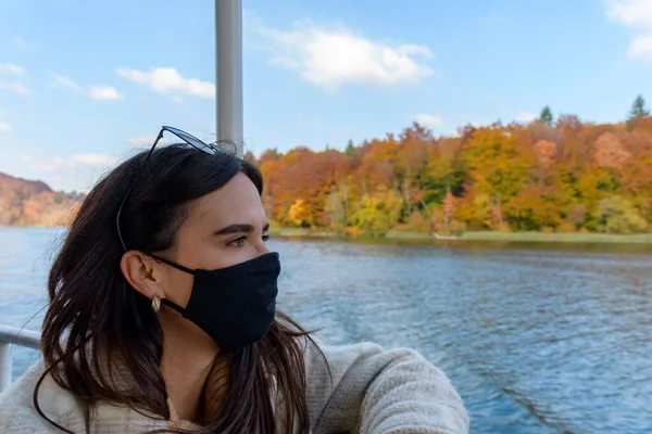 湖のほとりにある秋の森の美しい風景を背景にした若い女性 — ストック写真