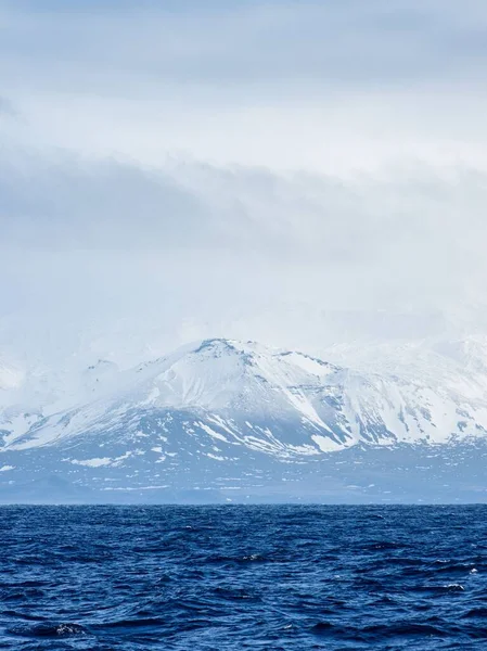 Okouzlující Pohled Zasněžené Hory Přes Hustou Mlhu Přes Modré Moře — Stock fotografie