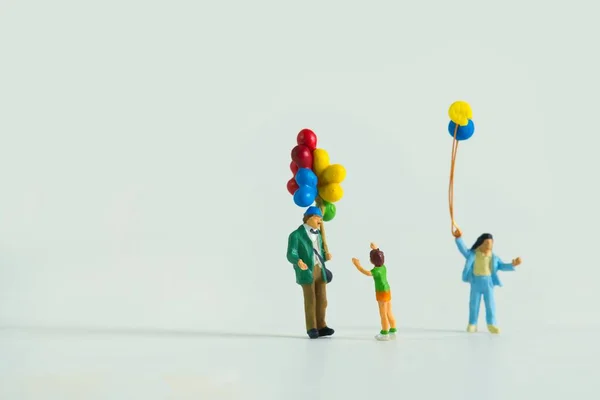 Zbliżenie Miniaturowe Figurki Mężczyzny Dzieci Balonami Odizolowanymi Białym Tle — Zdjęcie stockowe