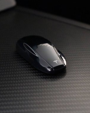 A vertical shot of a Tesla Model S Plaid key on the carbon fiber center console clipart