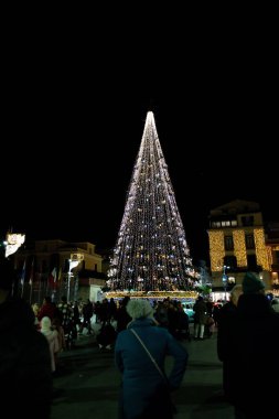 Sorrento 'da gece vakti Noel ağacından keyif alan insanların dikey görüntüsü parladı.