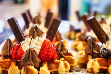 Bir kafede çikolatalı, dondurmalı ve çilekli waffle 'ın yakın plan çekimi.