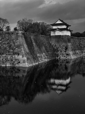 Kasvetli bir günde sahildeki bir Japon şatosunun gri pulu.