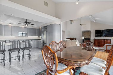 Kahverengi masa ve arka planda gri mutfak olan sandalyeler.