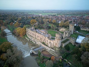 Warwickshire, İngiltere 'de ağaçlar ve nehirlerle çevrili eski bir Warwick Kalesi' nin hava görüntüsü.