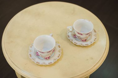 Mavi bardakta kahve. Ahşap bir masada. Işıklandırma arka planı olan bir kafede.