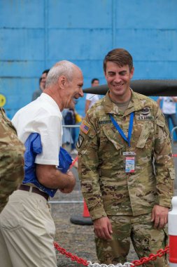 Bir gülen subay ve Bükreş Uluslararası Hava Gösterisi 'ndeki yaşlı bir adamın dikey çekimi.