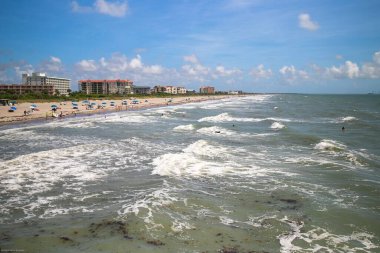 An aerial view of sea waves breaking sandy beach