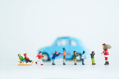 Beyaz arka planda izole edilmiş, Noel temalı minyatür bir figürün yakın plan çekimi.