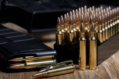 Çeşitli 223 (5.56x45mm) mermiler dolu bir şarjörde AR-15 'in yanında.