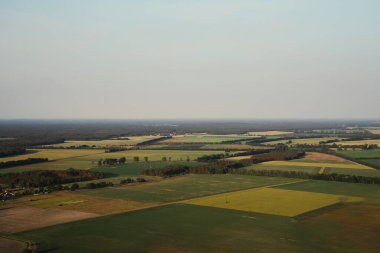 Sisli bir günde ormanlar ve tarlalar üzerinde hava manzarası