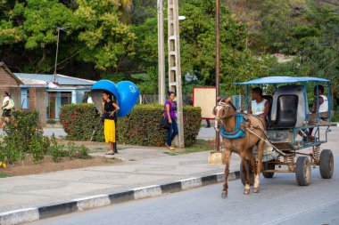 Santiago de Cuba caddesinde yolcu taşıyan yerel bir at arabası vardı.