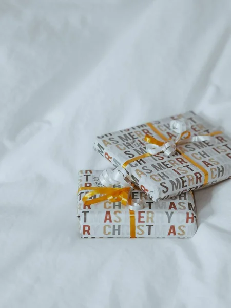 Plan Vertical Cadeaux Enveloppés Rubans Orange Blanc Sur Tissu Blanc — Photo