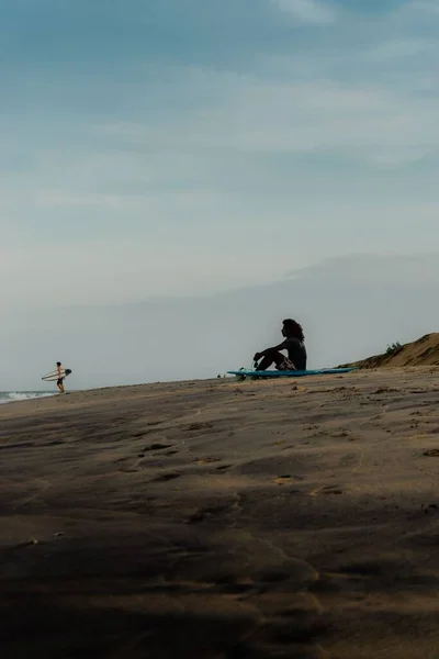 Pionowe Ujęcie Surfera Spoczywającego Plaży Błękitnym Niebem Tle — Zdjęcie stockowe