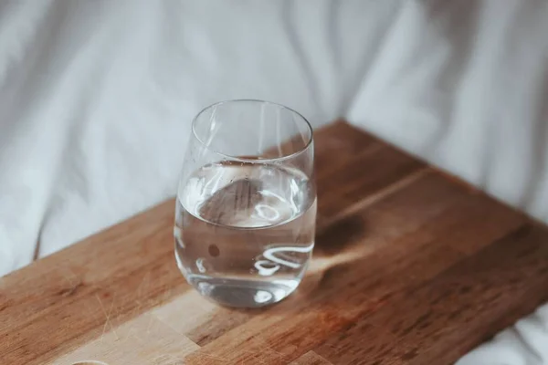 Nahaufnahme Eines Wasserglases Mit Einem Holzbrett Auf Weißem Stoff — Stockfoto