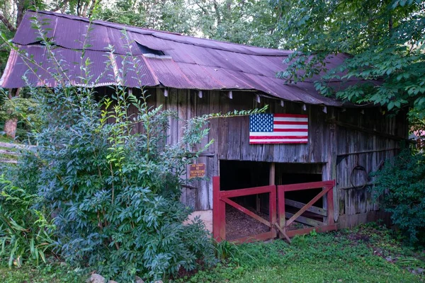 一张特写照片 拍的是在树林里的一个木制小木屋 上面挂着美国国旗 — 图库照片