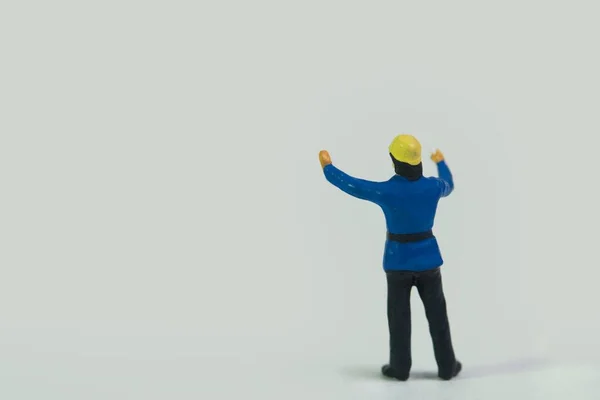 Een Miniatuur Figuur Van Een Brandweerman Staand Een Witte Achtergrond — Stockfoto