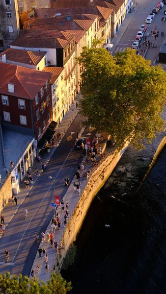 ポルトガルのポルトにある伝統的な建物の近くの川沿いの人々の垂直方向のトップビュー — ストック写真