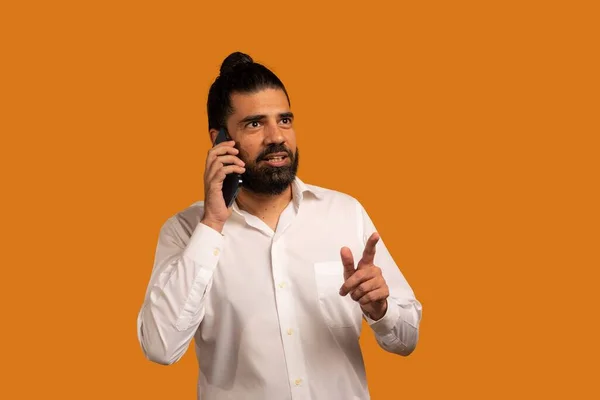 Гарний Знімок Іспанського Чоловіка Телефоном Показує Емоції Перед Помаранчевим Фоном — стокове фото
