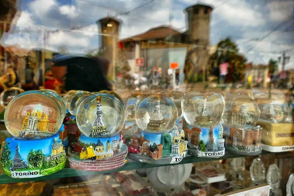 意大利都灵城堡广场的一个商店玻璃后面的各种纪念品的特写镜头 — 图库照片