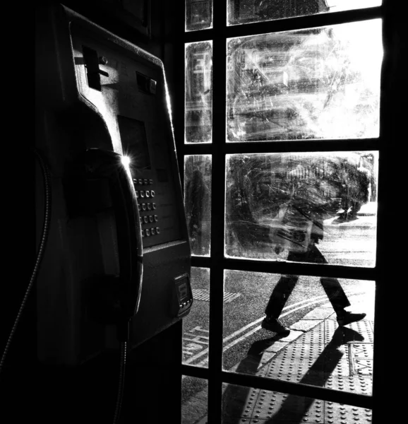 Szare Zbliżenie Starej Budki Telefonicznej Ludźmi Przechodzącymi Przez Ulice Widocznymi — Zdjęcie stockowe