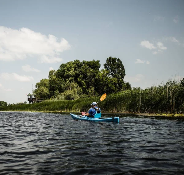 晴れた日に緑に囲まれた湖で男カヤック — ストック写真