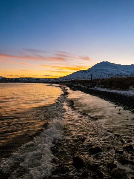 Dalgalı Denizin Zlanda Nın Karla Kaplı Dağlarının Üzerinde Gün Batımının — Stok fotoğraf